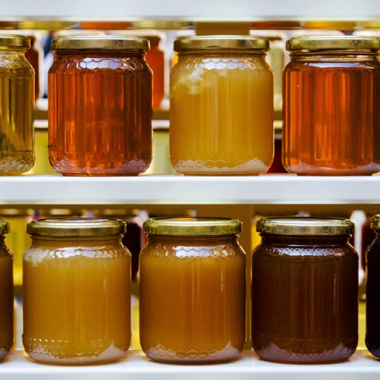 Honigläser in unterschiedlichen Honigfüllungen